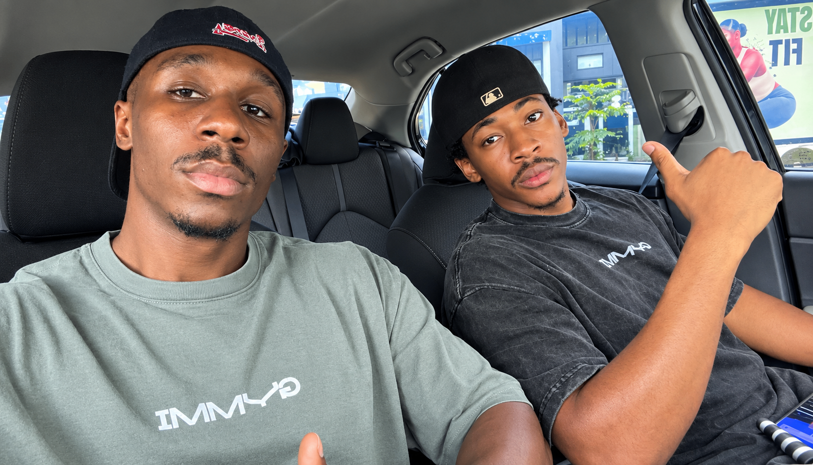 Two people in a car wearing GYMMI Gym Rat tees